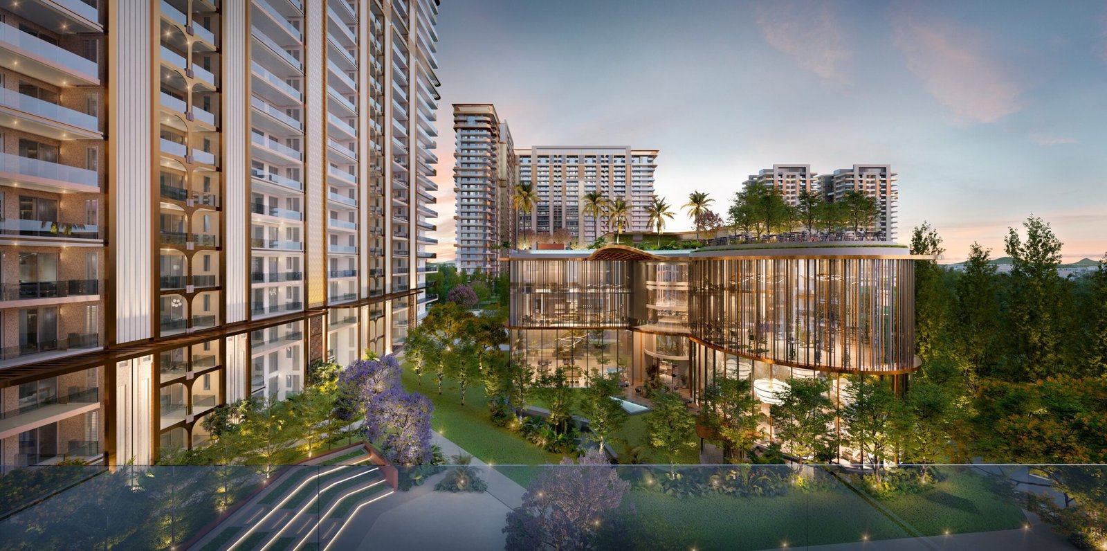 Modern residential complex with tall glass-clad towers, a curved glass atrium, and landscaped courtyard at dusk