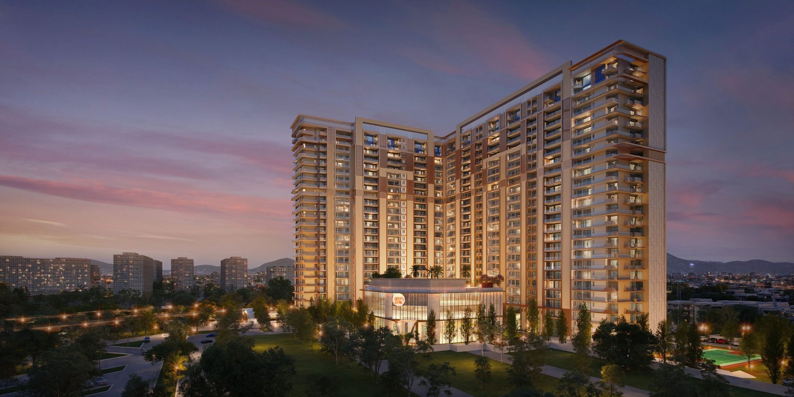 Modern high-rise apartment complex at dusk with illuminated windows and surrounding greenery.